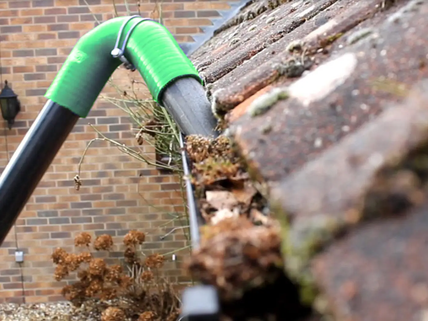 Gutter vacuum removing moss and debris from a blocked gutter