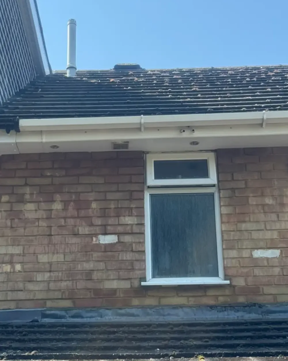 The same gutter line, soffits and bay roof cleaned back to a bright finish