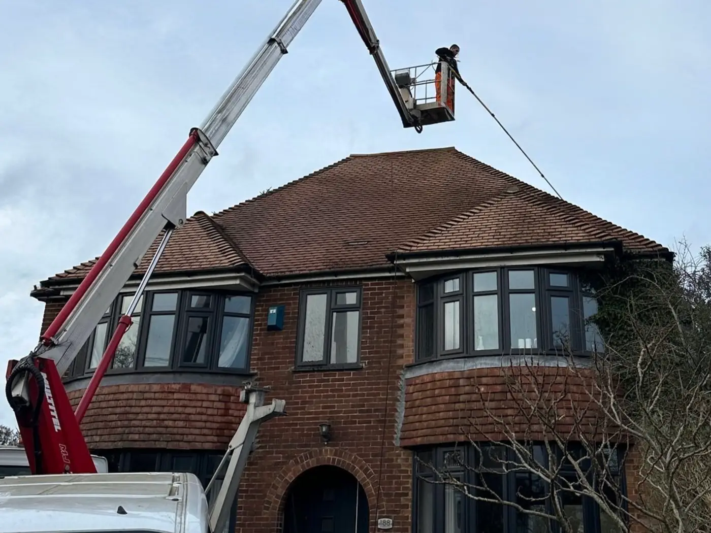 Access platform positioned beside a house for high level exterior cleaning