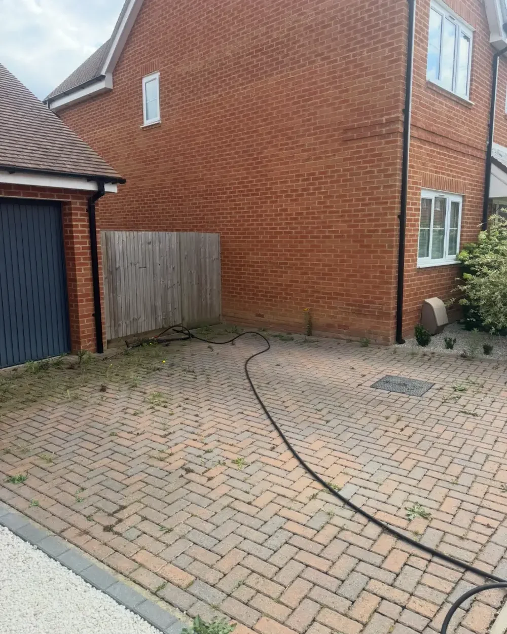Block paved driveway on a new build property soiled with algae before cleaning