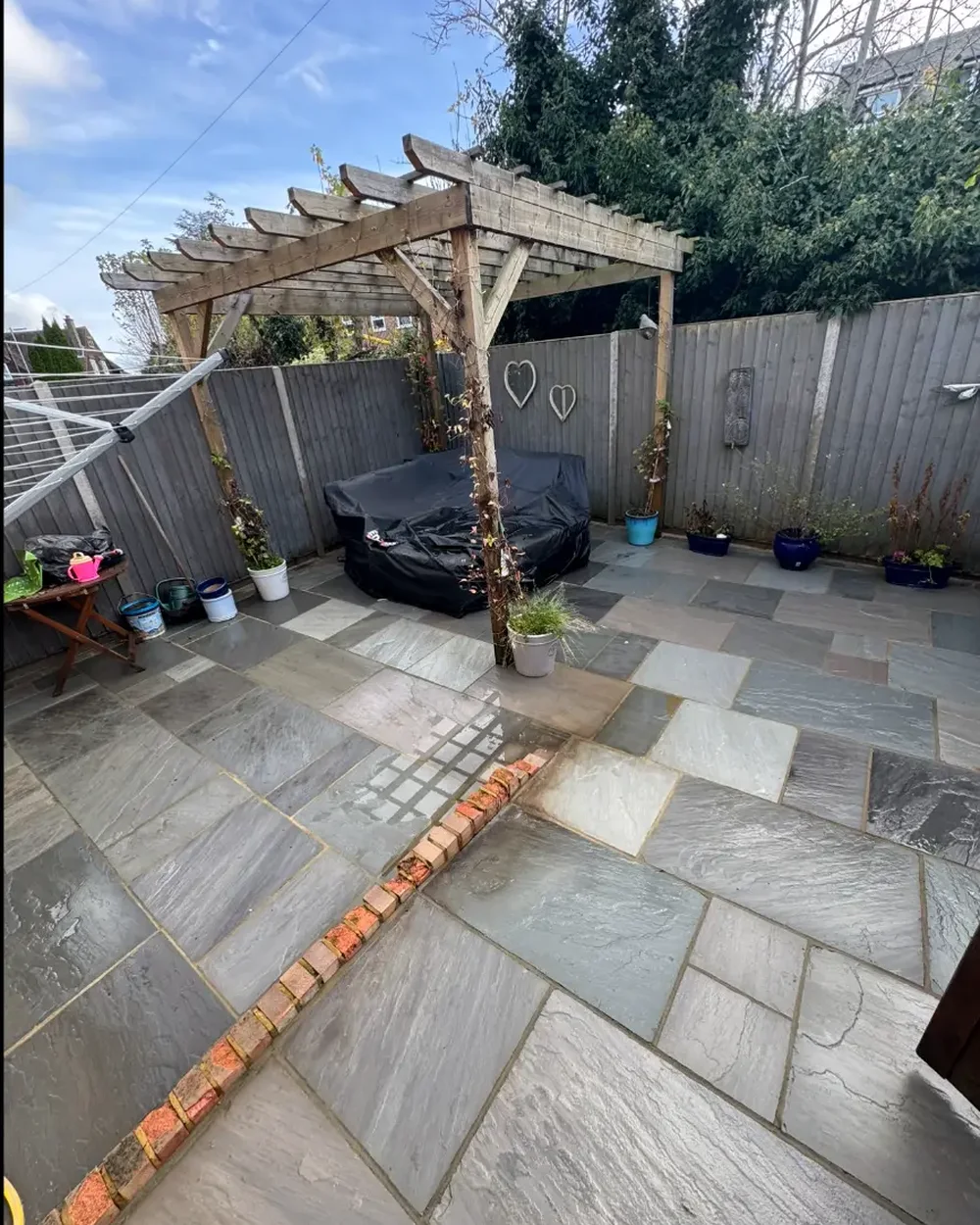 The same sandstone patio cleaned back to a clean grey and buff finish